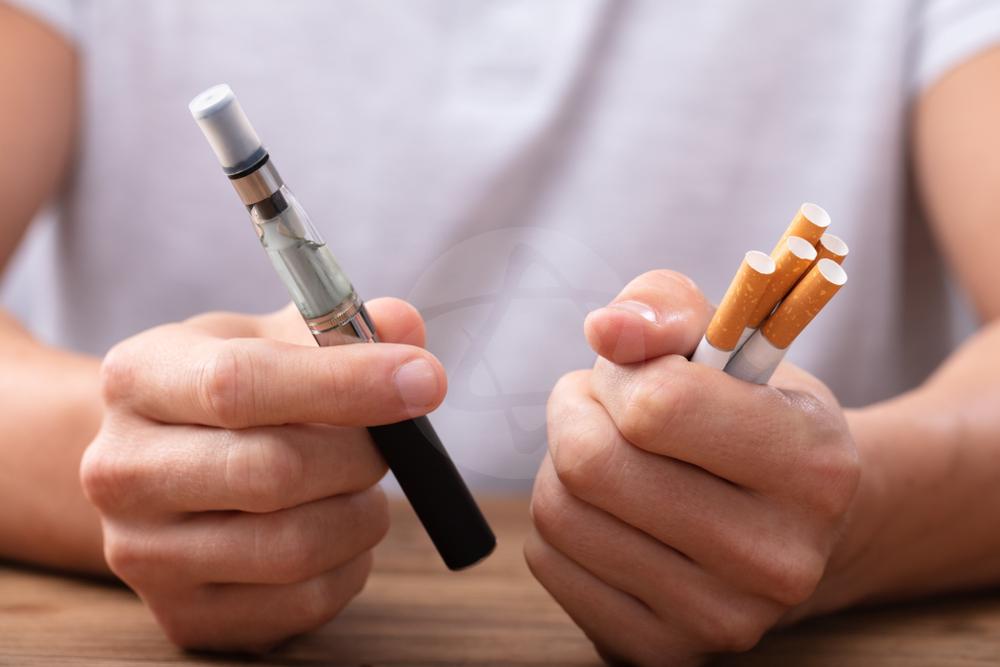 Homem segurando vape e cigarros